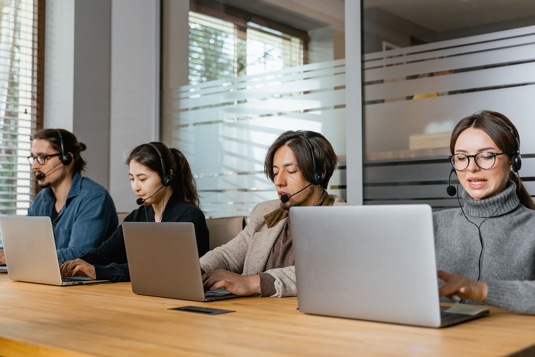 IT helpdesk support team working on laptops in a modern office